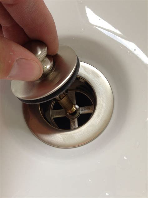 How to remove the drain plug. Lift up on the sink stopper to pull it out of the drain, taking care to avoid damaging the stopper. Loosen the nuts on the P-trap and disconnect it from the drain line to give yourself enough ... 
