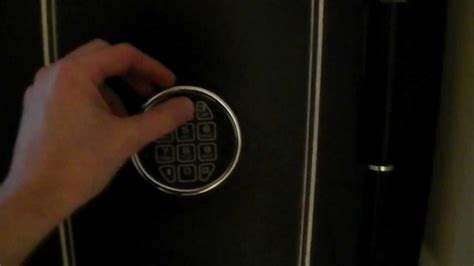 Open the safe using the existing combination or the override key. Locate the reset button (often found inside the door). Press and hold the reset button. Input your new combination on the keypad. Release the reset button. Test the new combination several times before closing the door.. 
