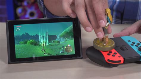 To scan amiibo in The Legend of Zelda Tears of the Kingdom hold the amiibo figure over the right control stick to scan it. This will register the amiibo in the game and provide you with the various rewards. If Breath of the Wild set the precedent, you will only be able to scan each amiibo figure once per day.. 