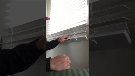 Using a screwdriver or pliers, carefully remove any screws or unclip the brackets to release the blinds. Be cautious not to damage the window frame or the blinds themselves. Once the brackets are removed, gently lower the blinds to the floor, making sure to keep them flat and avoid any twists or tangles as you go.. 