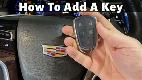 Make sure the vehicle is off. 2. Place the new transmitter into the transmitter pocket with the buttons facing the front of the vehicle. The transmitter pocket is inside the center console storage area between the driver and front passenger seats. 3. Insert the vehicle key into the key lock cylinder on the driver door.. 