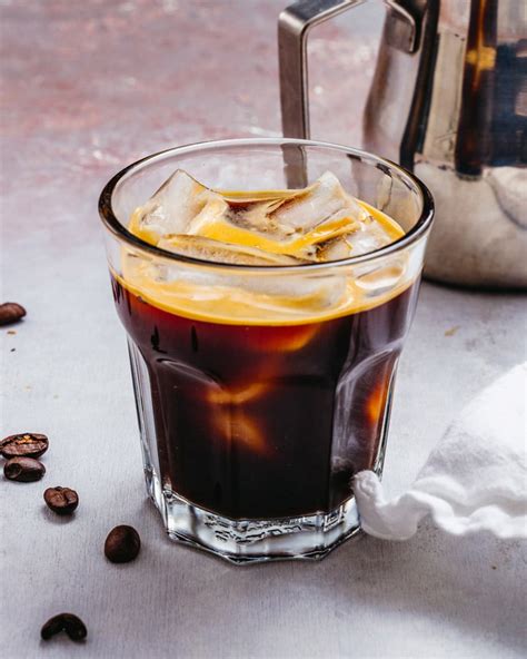 Ice americano. Fill a tall glass with ice. Pour the two shots of espresso over the ice. Add cold water to fill the glass to your desired taste. A common ratio is 1:2 espresso to water, but you can adjust to your preference. Stir the iced americano to … 