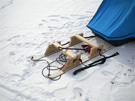 Here is a picture of my smitty sled I made years back for my lightweight 1 man shack. Small downhill ski's that glide real well and wood frame . Tub sits between the screw eyes which are my bungy cord anchors. Whether deep snow , slush, a couple inches of snow , bare ice, dry ground parking areas etc.... if I'm walking the smitty gets used.. 