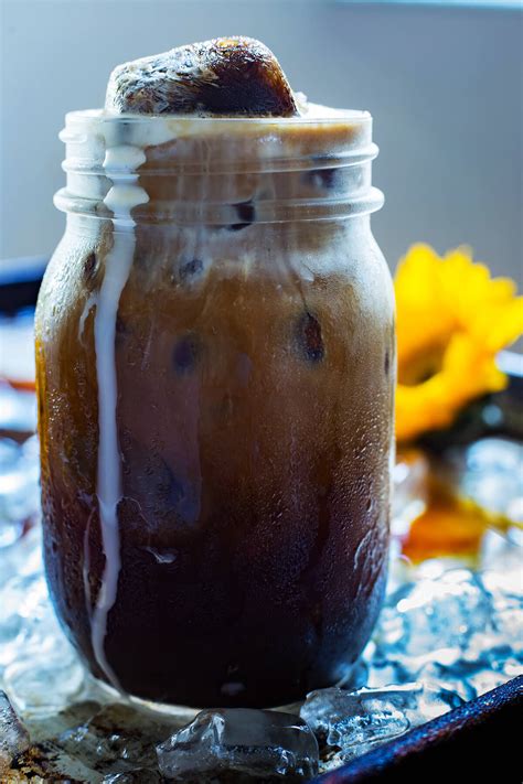 Iced coffee iced coffee. Brewed coffee contains more caffeine than Coca-Cola and iced tea. An 8-ounce serving of coffee contains between 80 and 135 milligrams of caffeine. Coca-Cola contains the least amou... 
