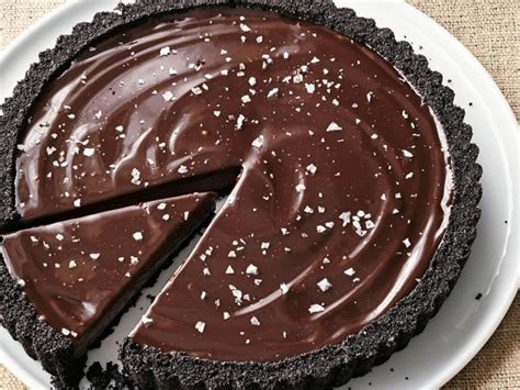 Ina garten chocolate tart. Preheat an oven to 375 F. Roll and trim the dough to make a circle large enough to fit a 10-inch fluted tart pan. Fit the circle into the bottom and up the sides of the pan. Line the dough with pie weights or dried beans and bake it for 15 minutes. Remove the pie weights and bake the shell for an additional 5 minutes. 