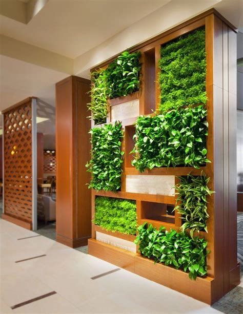 Indoor living wall. Living green walls are comprised of plants that are inserted into a growing medium and then places on the wall of buildings and properties to provide greenery and the benefits of plants, but using a minimum of horizontal space. An Ambius Green Wall is made up of various proprietary systems which are assembled in pieces on a structure which ... 