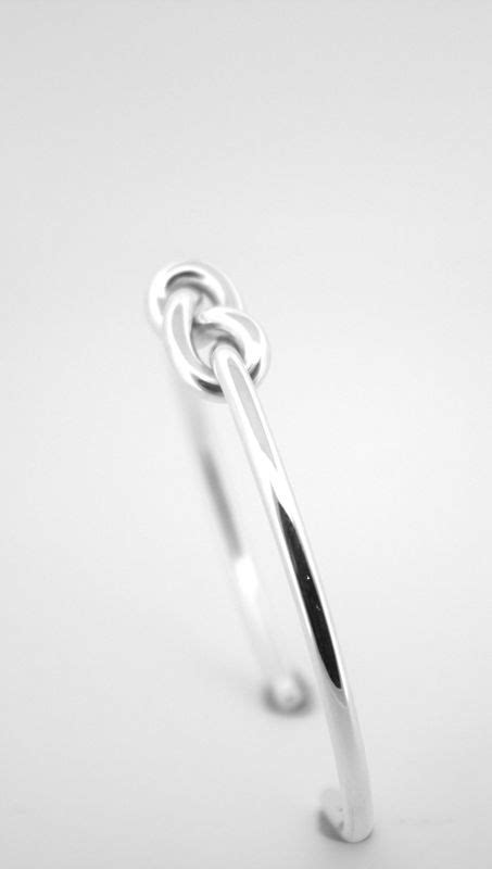 Infinity knot meaning.  Infinity Knot Center: A smooth silver infinity knot wraps around the...