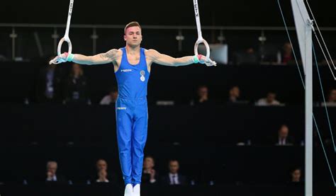 Iron cross gymnastics. The cross can be executed with a straight body, in L-sit, or in V-sit. The cross starts from the support position. The rings are turned out. The straight arms should slowly open sideways and the body should lower vertically until the arms reach horizontal. The body should remain straight for the entire skill. 