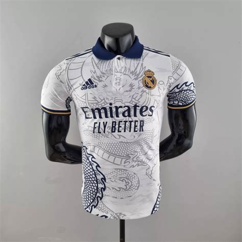 Jersey real madrid dragon. "Dive into the world of football fashion with the real madrid dragon kit 22/23. A blend of innovative design and cultural heritage, this Real Madrid jersey stands out as a symbol of strength and excellence. Ideal for fans and sports fashion enthusiasts." 