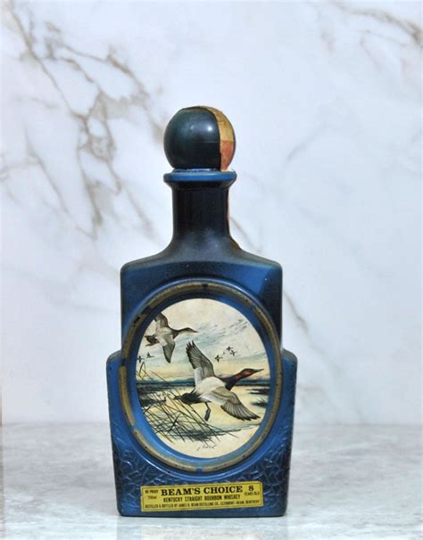 This listing is for an empty vintage 1981 Jim Beam whiskey decanter/bottle which held Kentucky straight bourbon whiskey. It is covered in an abstract pattern in shades of brown, and the front features ... Vintage Jim Beam Bourbon Whiskey THE ELK by J Lockhart Collectible Bottle .... 