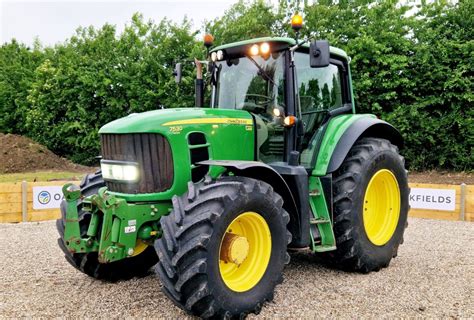 John deere 730 diesel engine.  John Deere 7530 tractor navigating through deep mud while pulling...