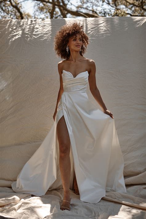 Katherine tash. Diana. KATHERINE TASH. Diana is perfect for brides searching for a classic Katherine Tash gown that offers more supportive structure. Beautifully pleated details on the front, tailored into a sleek back create a streamlined silhouette. Available with a dramatic matching overskirt. 