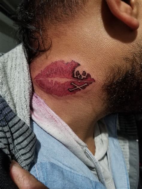 Kiss tattoo on the back of the neck.