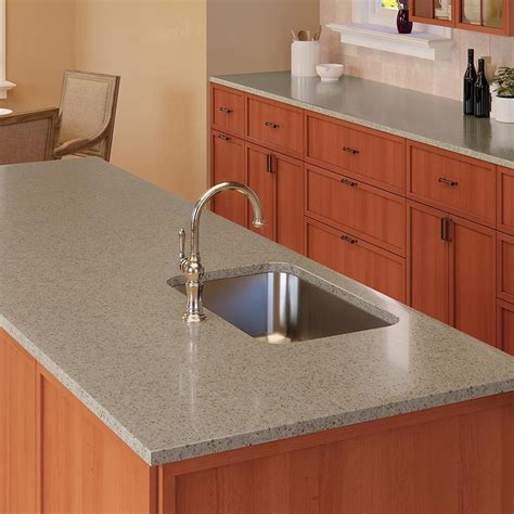 The standard width of a kitchen countertop is 25 inches. Base cabinets are generally 24 inches deep, and countertops have a 1-inch overhang. The 25-inch width provides space for a sink or a cooktop.. 