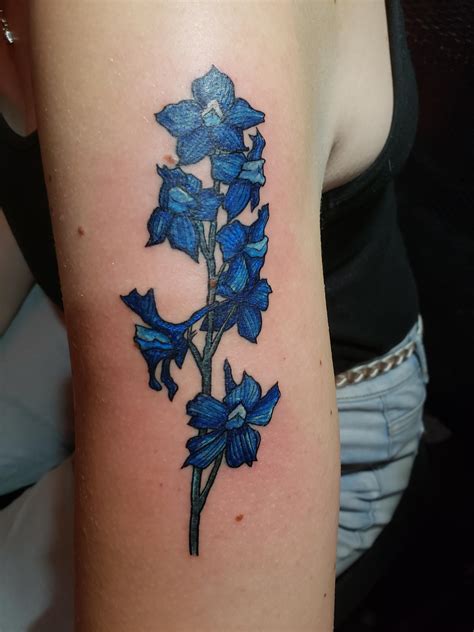 A larkspur flower tattoo offers a range of uplifting meanings linked w