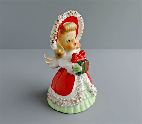 Cute Lefton girl bell with spaghetti trim holding Christmas tree o