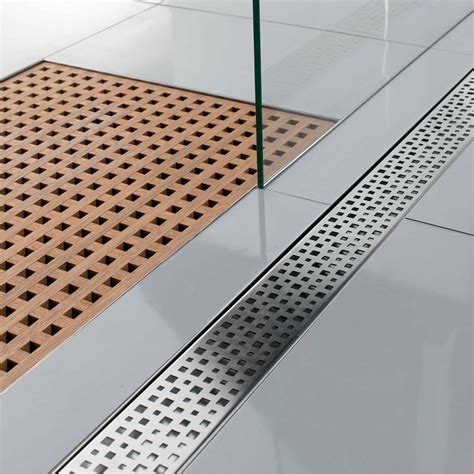 Linear drain. Highlights. 304 grade stainless steel construction has a sloped channel to ensure proper drainage. Brushed gold drain and grate finish. Ideal shower drain for large format tiles. Adjustable leveling feet for quick and easy height adjustment during installation. Includes lifting key for ease of drain cover removal during cleaning and maintenance. 