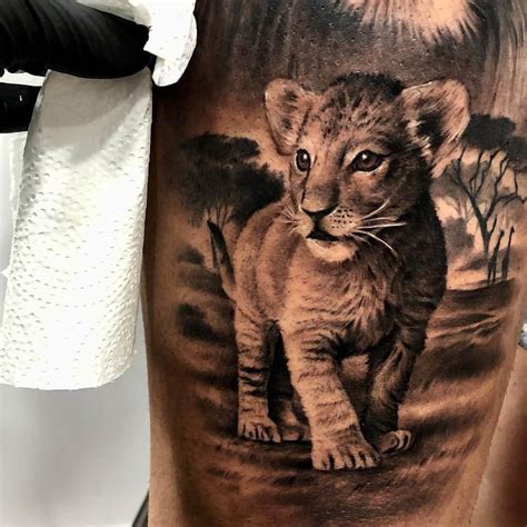 Discover a beautiful tattoo design featuring a lioness and her two cubs. This artistic drawing showcases the bond between a mother lion and her offspring, with the addition of intricate floral elements. Perfect for those who appreciate nature and family-inspired tattoos..