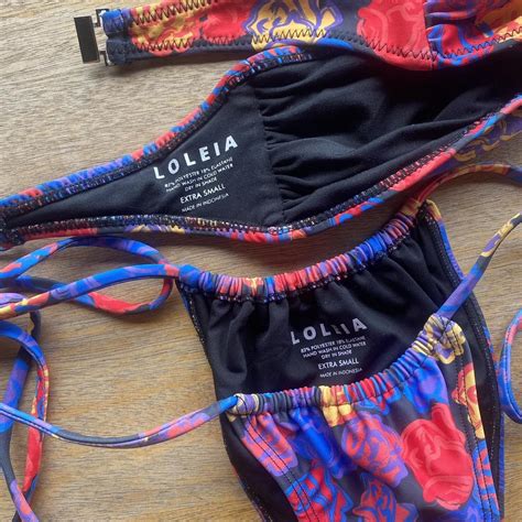 Loleia swim. An Amelie Teje and Loleia Swim Collaboration Fields of Poppies Scrunchie Bottoms Original graphic, designed in Australia. Sunset orange gingham, AT x LS logo and red floral. Saskia wears extra small, size up if in between. Produced in Indonesia. 