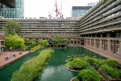 London's barbican. The final cost of building Barbican Centre in 1982 was £156 million, which in today’s money would be £500 million. Its total floor area is 20 acres and the total area of the grounds is 35 acres. The entire Barbican development contains over 130,000 cubic metres of concrete, which is enough to build roughly 19 miles of a six-lane motorway. 
