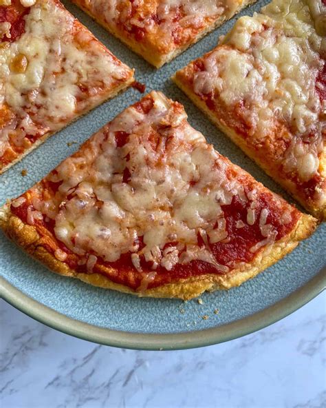 Low cal pizza. Spread the sauce over the crust. Top with cheese and place the pan on the pizza stone, bake 10 to 12 minutes or until the cheese is bubbly and the crust is cooked through. Transfer to a cutting board, top with basil and drizzle with olive oil, if desired. Slice the pie into 8 slices. 