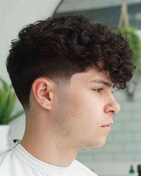 Low taper fade for curly hair. Curly Pompadour with Low Taper Fade. The low taper fade is a popular choice for men with curly hair. This hairstyle features a low fade that tapers down to the skin at the sides and back. The pompadour is a classic men’s hairstyle that can be worn with a variety of different hair types and lengths. 