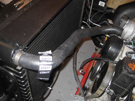 Bottom hose; Toyota Landcruiser Diesel Hose 11/80 On; Gates p/n 05-0435. It works well and doesn't take up much space. 0.75" behind the radiator support, at the outer edge of the fan, 1" in the center of the fan. No mods to the radiator support, just trim the side panels. Ignore the front fan, that is an additional one for the AC.. 