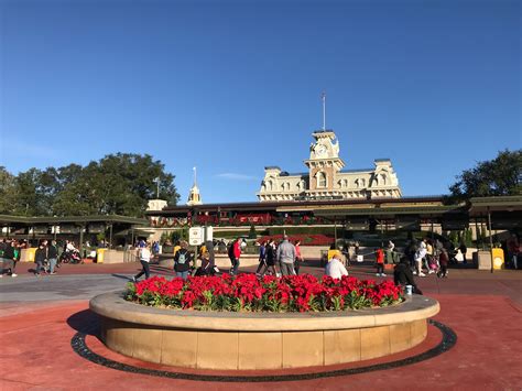 Magic kingdom entrance. Main Street is designed to seem the entrance to a new show, Magic Kingdom's intention. The turnstiles are like the entry to a grand theater. Under the train station, posters of the park's attractions are shown to tell the guest what to expect and building the excitement. Then, the smell of fresh pop corn welcomes the guests as they enter the show. 