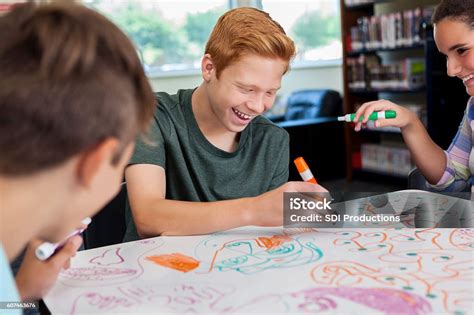 Makerspace annapolis.  Getty Images.  Cheerful teenagers drawing together at local m...