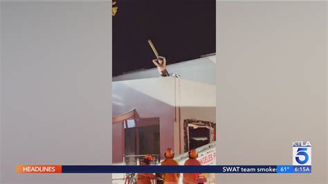 Man on Venice rooftop throws pieces of wood at firefighters