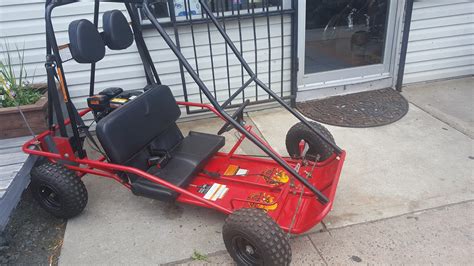 Old 2 seat Manco Critter 2 go cart. Engine turns over by hand but I wouldn't count on it running. Mostly complete except for the rear axle is broken off and the wheel is missing. May trade for guitar.. 