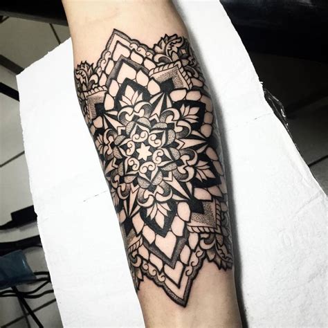 Mandala tattoo on the right inner forearm.