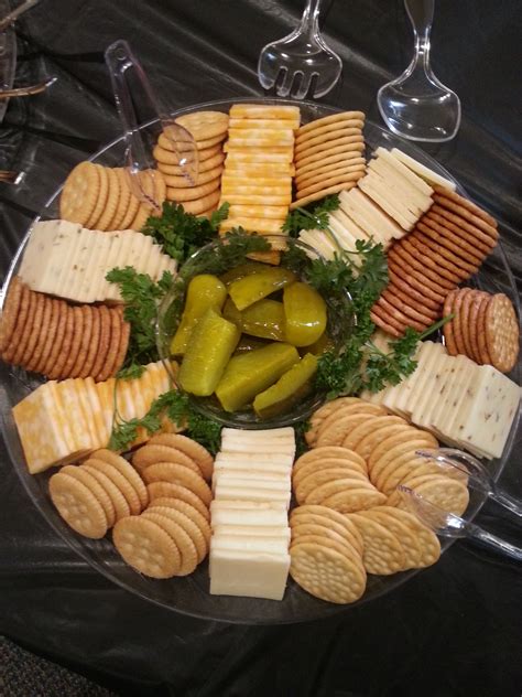 Meat cheese and cracker tray. 3. Arrange Cheese. Place the cheese on a platter or large cutting board, starting with the larger pieces of cheese. Leave enough space between the cheeses to access each type easily. You can choose to either slice your cheese or cube your cheese and stack them up so that it's easier for your guests to grab. 