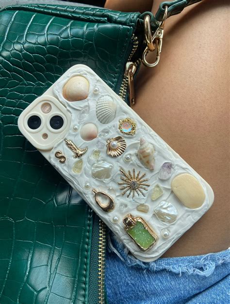 Memor phone case. Customizable Memor Inspired Handmade iPhone Case. Personalized w/ hand-picked seashells, shark teeth, sea glass, and charms from FL beaches. (32) $32.99. Handcrafted Memor inspired iPhone Case. Each case is unique. Made with hand picked Sanibel shells, authentic crystals, and charms. (821) $39.00. 