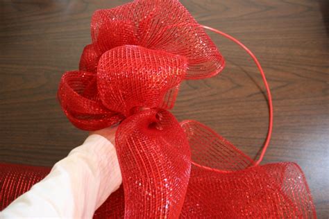 Red jingle bells. Scissors. Instructions. Cut the pipe cleaners into 2-inch pieces. Form a loop at one end of the ribbon or deco mesh roll. Secure the loop to the wire wreath with a red pipe cleaner. Continue securing loops around the outside and inside edge of the wreath. Alternate between the outside and inside.. 
