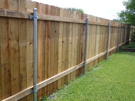 Metal post for wood fence. How to install a wood fence but use steel fence posts. This video shows how easy it is to have the look of an all wood fence, but retain the strength of ste... 