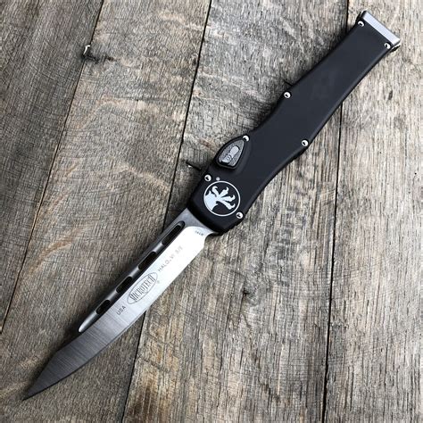 Microtech knives halo. The Microtech Halo V is a huge Single action push button activated Out The Front (otf) Knife. Almost 11" total length with a 4.6" blade. The 6061-T6 aluminum frame and charging handle are anodized and the knife includes a molded black sheath with belt attachment system. 