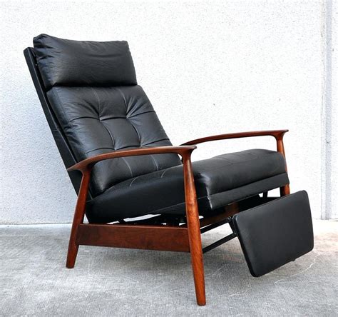 Mid century modern recliner. Put your feet up + relax in this push-back recliner – without compromising on aesthetics. Inspired by mid-century modern design, it showcases a contoured wooden frame with plush cushions wrapped in easy-care vegan leather. It moves from an upright position to the nearly flat “nap zone.” Reclining Type: Manual; Position Type: 3-Position 