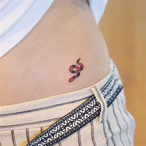 Minimalist snake tattoo on the left hip