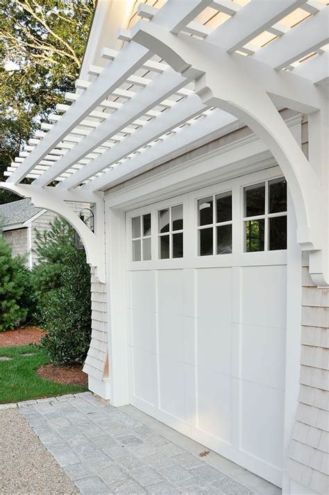 Modern pergola over garage door. This awning style pergola creates a dramatic statement above your garage door. Unlike most pergolas, it does not have support columns that reach the ground. Instead, this pergola attaches to the garage wall. Vines growing on both sides of the door fill in where the supports would be, suggesting the presence of the support posts. 5. 