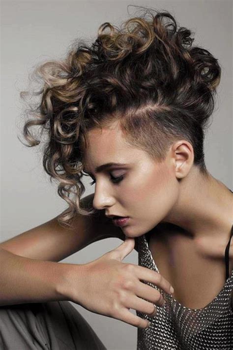 The left view of this short curly mohawk hairstyle for black women showcases the side part and the barrel curls throughout the sides and top. Sleeking or braiding the sides, you draw attention to the outlines of your face, facial features, and a beautiful neckline. Take the adventurous route and buzz cut all of it.. 