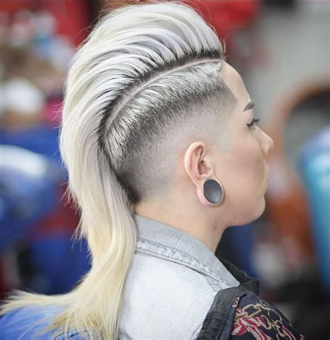 Mohawk long hairstyles. Combining the edgy vibe of a mohawk with the sleekness of a fade, this haircut offers a unique and stylish look. The mohawk fade features longer hair on the top, gradually tapers into shorter sides, creating a striking contrast. This hairstyle works well with blonde hair color for men, adding an element of boldness. Instagram @morslibarber. 