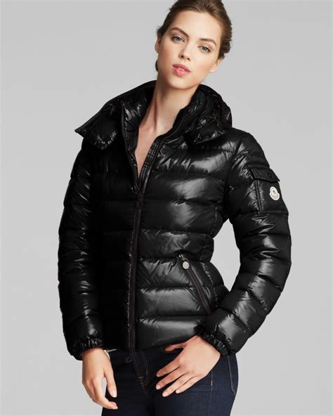 Moncler short down jacket women's. Emblematic of Moncler's DNA, the Bady down jacket for women is crafted from glossy nylon laqué with iconic boudin quilting. A timeless design that transcends seasons and trends, the short puffer jacket features a strong silhouette, a detachable hood and adjustable hemline. A brand signature, a classic patch pocket, adorns the Bady's sleeve. 