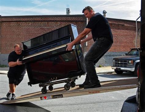 Moving a piano. Cover the piano with a moving blanket. Tape the blanket to secure it in place. Have each person move to a corner of the piano, then lift to hoist it onto the dolly. (Remember to bend knees to avoid back injury.) Carefully push the piano out to the moving van, with each helper remaining on their corner to assist; Moving a Grand Piano, Step by ... 