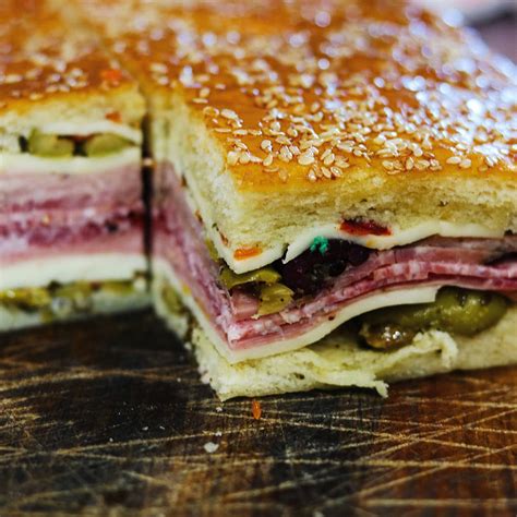 Muffaletta new orleans. Directions. Preheat the oven to 375 degrees F. Spread the cut sides of each half of bread with equal amounts of the olive salad and oil, about 1 1/2 cups per side. Arrange the mozzarella over the ... 