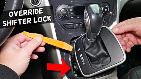Remove the cap and push down on the button with a nail file or other pointed object. As you are pushing the button down, step on the brake pedal, move the shifter into neutral, and start the car. Note that releasing the shifter will only bypass the problem, if the problem was a locked shifter. There will be other issues to take care of, but .... 