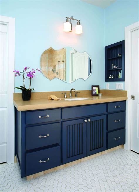 Navy blue bathroom cabinets. Christina Schmidhofer. A color scheme of navy blue, white, and polished chrome is a classic blue bathroom idea. Complete with a freestanding bathtub, this bathroom showcases the combination in elegant style. The built-in shelves and large vanity provide plenty of storage while also breaking up the navy walls with contrasting white. 