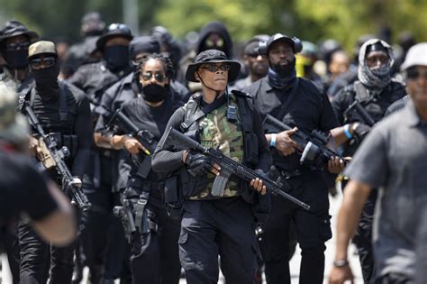 John "Grandmaster Jay" Johnson, center, leader of an all-Black militia group called NFAC, leads a march during an armed rally in Louisville, Kentucky, July 25, 2020. A group of heavily armed Black pro. 
