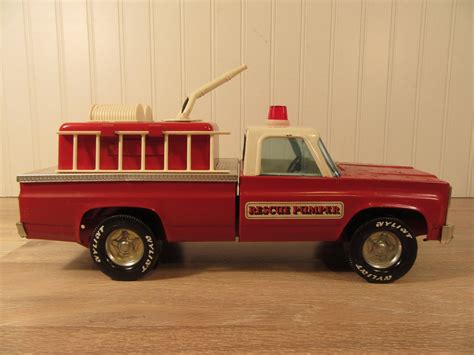 Nylint fire truck. This is a vintage Nylint metal toy truck designed as a fire department rescue pumper vehicle. It features a red and white color scheme and is recommended for children aged 5 and up. The toy is not autographed or customized and is suitable for both boys and girls. 