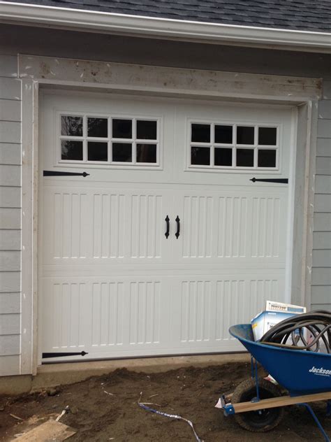 One car garage door. While the track, rollers, springs, and hinges are often included in the door price, installation and carting off the old door are not. The labor to install a new door typically costs between $300 and $500, and includes discarding the old door and hooking up an opener. Add $50 to $100 for a wider two-car door. 